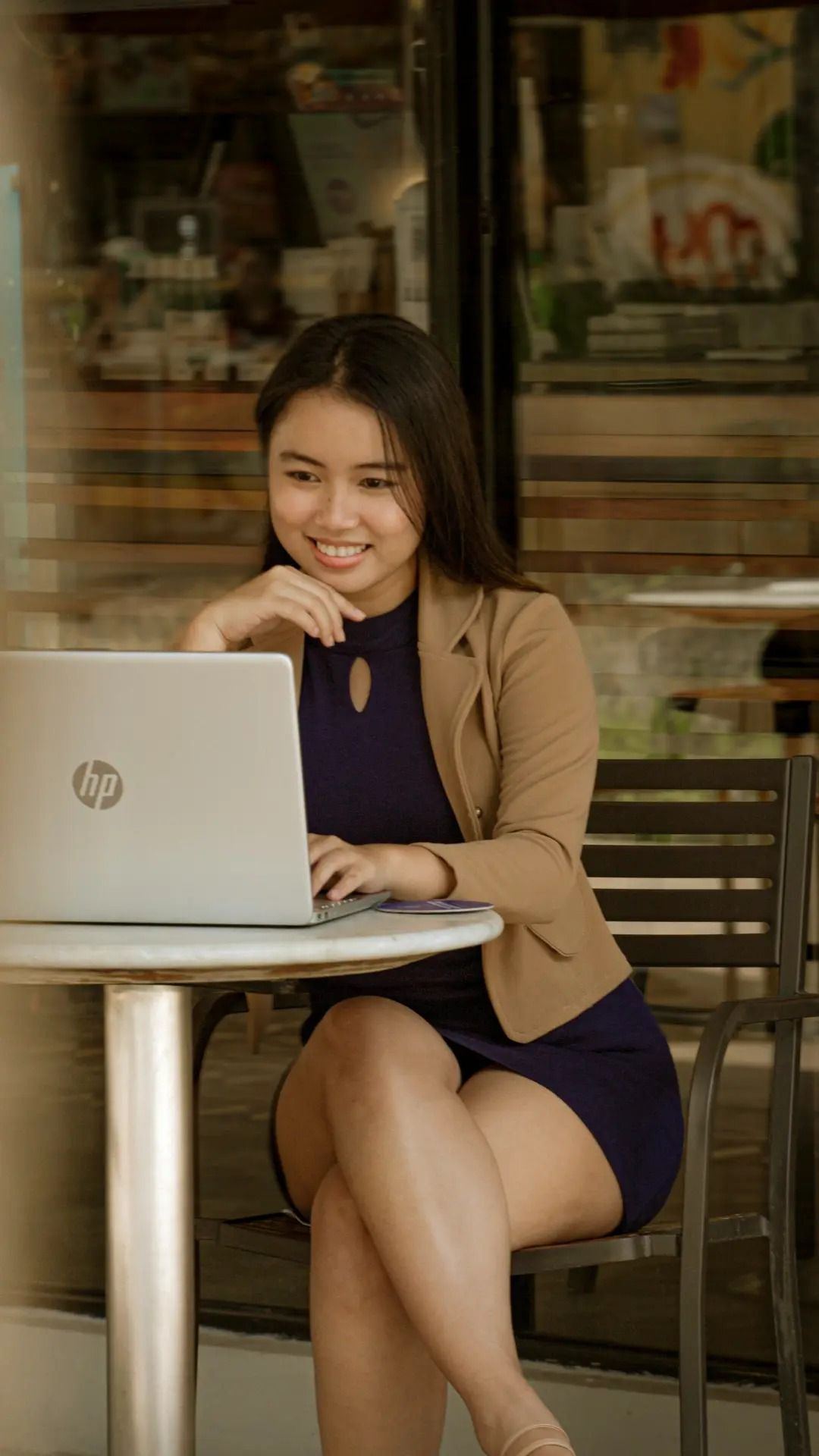 An independent freelancer working on a laptop at a cafe table