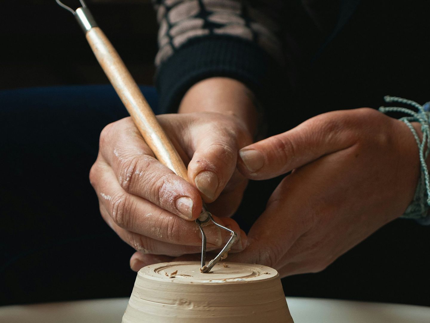 A maker shaping clay by hand in a creative studio